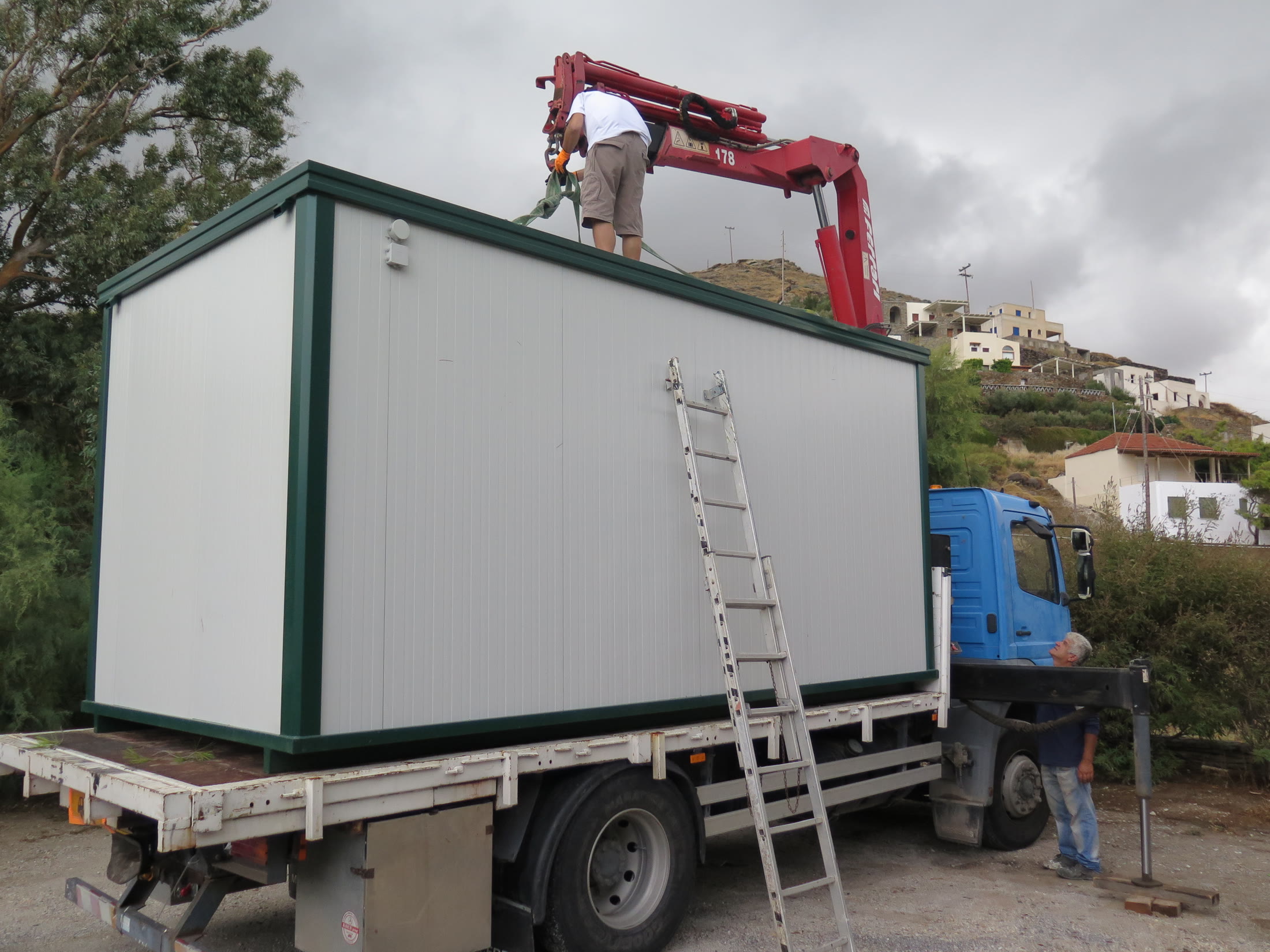 Marine production support container being installed at a coastal location