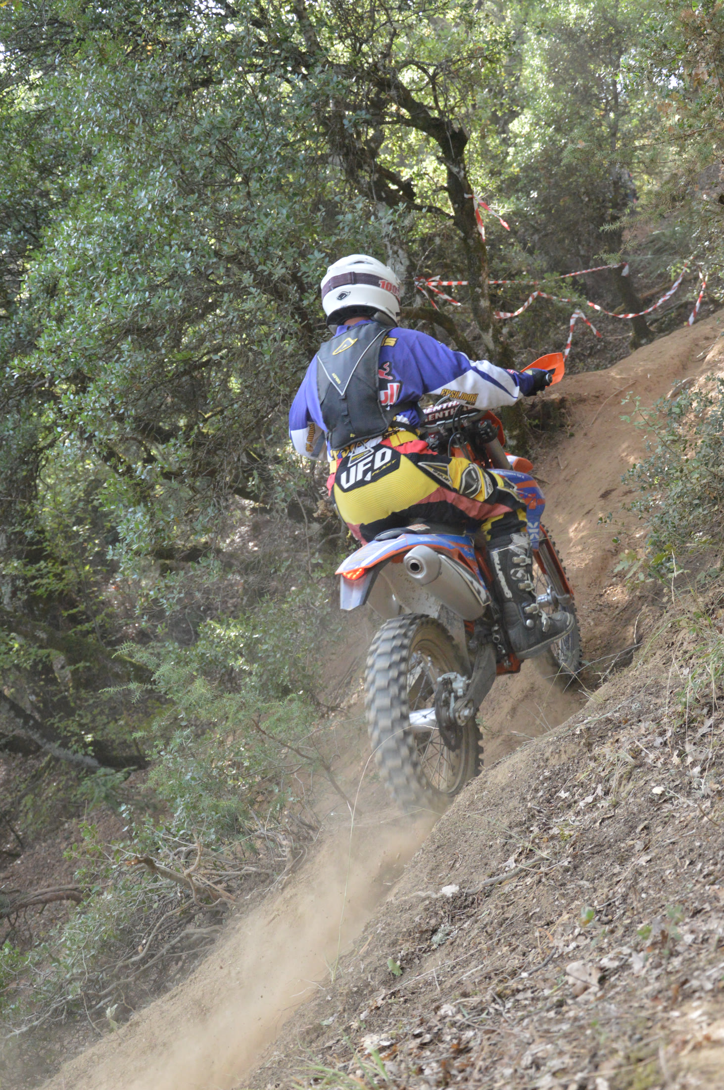 Enduro rider climbing a steep forest trail